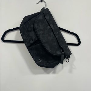 Lululemon sling purse (no strap). Zipper pocket, and two open other pockets.